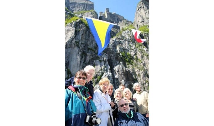 En del av MIFF-medlemmene som var med på båtturen, med Prekestolen som troner 600 meter over havet i bakgrunnen. (Foto: Conrad Myrland, MIFF) En del av MIFF-medlemmene som var med på båtturen, med Prekestolen som troner 600 meter over havet i bakgrunnen. (Foto: Conrad Myrland, MIFF)