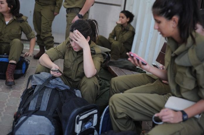 Ferske israelske rekrutter sender en siste tekstmelding hjem før de får beskjed om å slå av sine private mobiltelefoner. (Illustrasjon: IDF) Ferske israelske rekrutter sender en siste tekstmelding hjem før de får beskjed om å slå av sine private mobiltelefoner. (Illustrasjon: IDF)