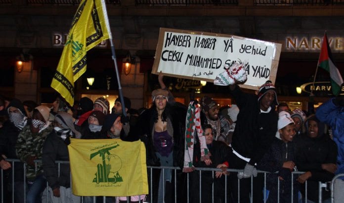Da Israel-venner holdt en støttemarkering for Israel i Oslo 8. januar 2009 holdt noen av motdemonstrantene opp dette banneret. Teksten er en trussel om å gjenta Muhammeds massakre av de tre jødiske stammene i Hayber. Legg også merke til de gule flaggene for terrororganisasjonen Hizbollah. (Arkivfoto: Odd Østtveit) Da Israel-venner holdt en støttemarkering for Israel i Oslo 8. januar 2009 holdt noen av motdemonstrantene opp dette banneret. Teksten er en trussel om å gjenta Muhammeds massakre av de tre jødiske stammene i Hayber. Legg også merke til de gule flaggene for terrororganisasjonen Hizbollah. (Arkivfoto: Odd Østtveit)