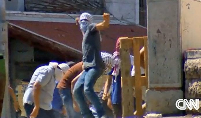 Maskerte palestinere kaster stein mot israelsk politi i Jerusalem. (Foto: Skjermdump fra CNN 6. juli 2014) Maskerte palestinere kaster stein mot israelsk politi i Jerusalem. (Foto: Skjermdump fra CNN 6. juli 2014)