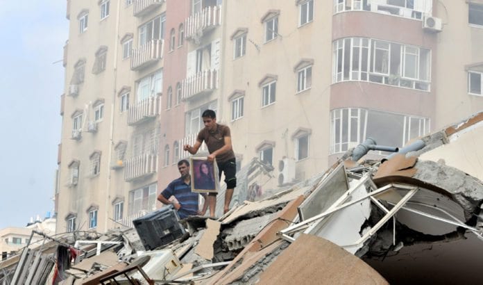 Palestinere rydder opp i ruinene av et høyhus som ble bombet av israelske luftstyrker 24. august 2014. Til tross for de store ødeleggelsene anser et flertall av palestinerne krigen som en seier. (Foto: Shareef Sarhan, FN, flickr.com) Palestinere rydder opp i ruinene av et høyhus som ble bombet av israelske luftstyrker 24. august 2014. Til tross for de store ødeleggelsene anser et flertall av palestinerne krigen som en seier. (Foto: Shareef Sarhan, FN, flickr.com)