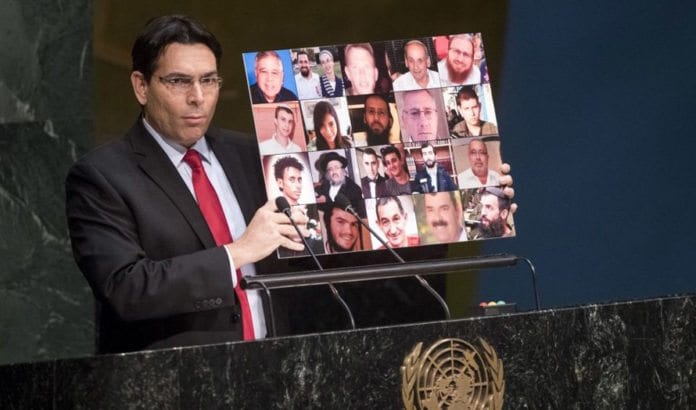 Israels FN-ambassadør Danny Danon holdt opp plakat med bilder av høstens israelske terrorofre for FNs generalforsamling i fjor.(Foto: FN) Israels FN-ambassadør Danny Danon holdt opp plakat med bilder av høstens israelske terrorofre for FNs generalforsamling i fjor.(Foto: FN)