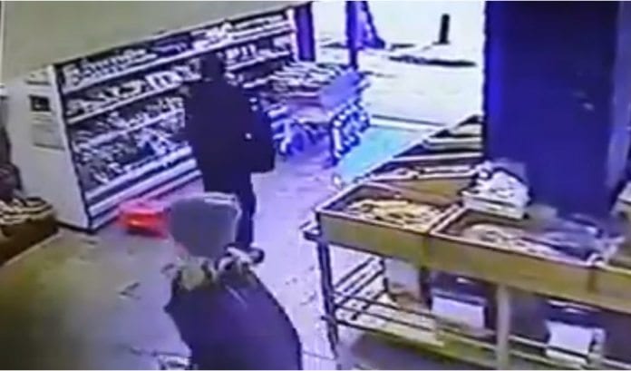 Overvåkningsfilm viser angriperen som plukker opp noen nøtter, legger dem tilbake, tar ut skytevåpen fra ryggsekken sin og begynner å skyte utenfor butikken. (Skjermdump via Jpost.com) Overvåkningsfilm viser angriperen som plukker opp noen nøtter, legger dem tilbake, tar ut skytevåpen fra ryggsekken sin og begynner å skyte utenfor butikken. (Skjermdump via Jpost.com)