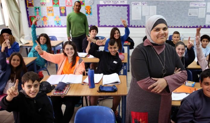 Den arabisk-israelske læreren Nedaa Rabi er her sammen med klassen hun underviser på Gvanim ungdomskole i Qadima. Skolen har ansatt fem arabiske lærere og er et vellykket eksempel på utdanningsdepartementets integreringsprogram. (Foto: Hadas Parush/Flash 90) Den arabisk-israelske læreren Nedaa Rabi er her sammen med klassen hun underviser på Gvanim ungdomskole i Qadima. Skolen har ansatt fem arabiske lærere og er et vellykket eksempel på utdanningsdepartementets integreringsprogram. (Foto: Hadas Parush/Flash 90)