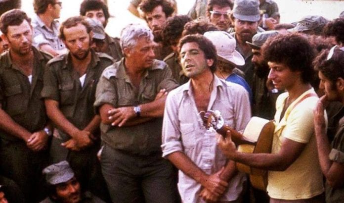 Leonard Cohen sammen med Ariel Sharon under Yom Kippur krigen i 1973. Cohen var på turne i Hellas, men så snart han hørte om krigen som brøt ut, reiste han fra alt for å støtte de israelske troppene. (Foto: Stand With Us) Leonard Cohen sammen med Ariel Sharon under Yom Kippur krigen i 1973. Cohen var på turne i Hellas, men så snart han hørte om krigen som brøt ut, reiste han fra alt for å støtte de israelske troppene. (Foto: Stand With Us)