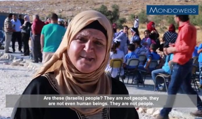 «Israelerne er ikke folk, de er ikke en gang mennesker,» sier en kvinne i landsbyen som satte opp en brakkeskole ulovlig sammen med Flyktninghjelpen. (Skjermdump fra Mondoweiss/ YouTube) «Israelerne er ikke folk, de er ikke en gang mennesker,» sier en kvinne i landsbyen som satte opp en brakkeskole ulovlig sammen med Flyktninghjelpen. (Skjermdump fra Mondoweiss/ YouTube)