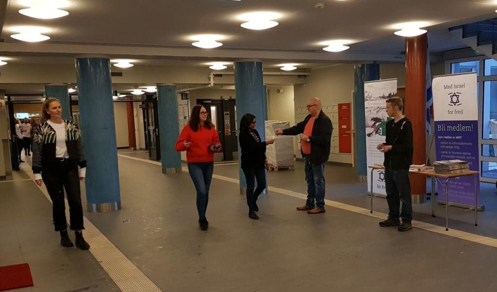En forbipasserende mottar minifolderen fra MIFF-medlem Knut Willy Johnsen.