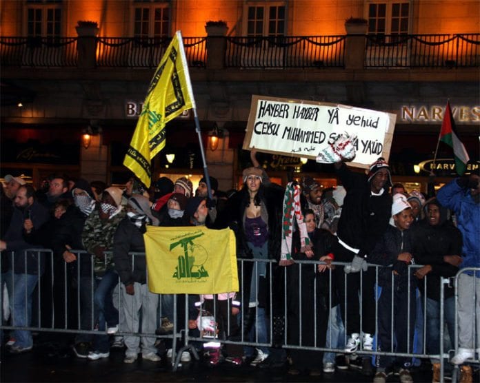 Da Israel-venner holdt en støttemarkering for Israel i Oslo 8. januar 2009 holdt noen av motdemonstrantene opp dette banneret. Teksten er en trussel om å gjenta Muhammeds massakre av de tre jødiske stammene i Khaybar. Det samme slagordet ble ropt i Oslo 22. juli 2017 og i Malmö 8. desember 2017. (Arkivfoto: Odd Østtveit) Da Israel-venner holdt en støttemarkering for Israel i Oslo 8. januar 2009 holdt noen av motdemonstrantene opp dette banneret. Teksten er en trussel om å gjenta Muhammeds massakre av de tre jødiske stammene i Khaybar. Det samme slagordet ble ropt i Oslo 22. juli 2017 og i Malmö 8. desember 2017. (Arkivfoto: Odd Østtveit)
