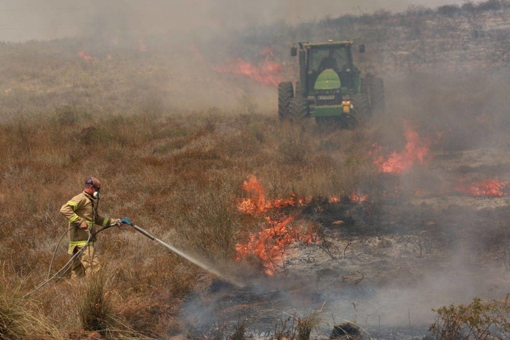 En israelsk brannmann forsøker å slokke flammene. (Foto: Ofer Levy/Facebook)