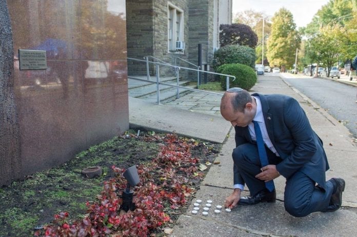 Naftali_Bennett Israels diasporaminister Naftali Bennett tenner et lys utenfor synagogen som ble angrepet lørdag. (Foto: Facebook)
