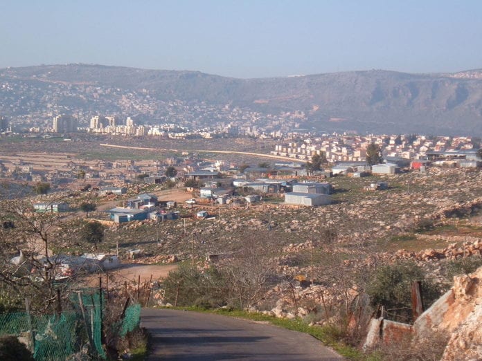 1280px-Arabnaim I dette bildet av Arab al-Naim fra 2006 ser man at de fleste bodde i enkle skur. I dag bor de fleste i moderne boliger. (Foto: Wikipedia)