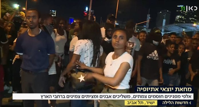 Bildet viser etiopisk-israelsk ungdom som deltar i en demonstasjon utenfor Azrielisenteret i Tel Aviv tirsdag kveld. (Skjermdump fra Kan)