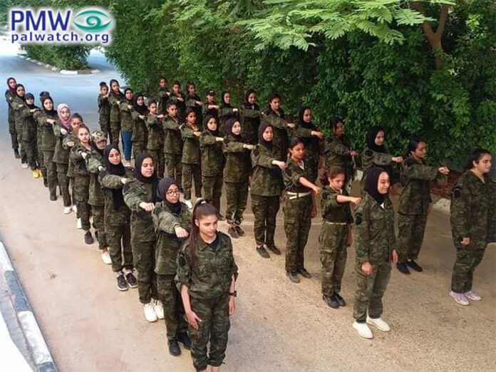 Tenåringsjenter blir trent i militæruniform på en sommerleir oppkalt etter en terrorist. Det hele er indirekte sponset av norske bistandspenger. (Foto: Shabiba, via Palestinian Media Watch)